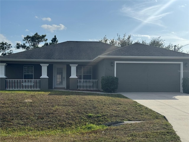 view of front of house featuring covered porch, a front yard, and a garage