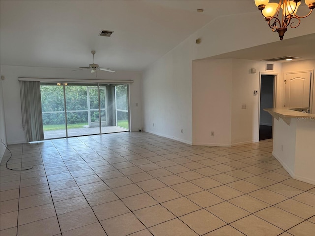 tiled spare room featuring ceiling fan with notable chandelier and vaulted ceiling