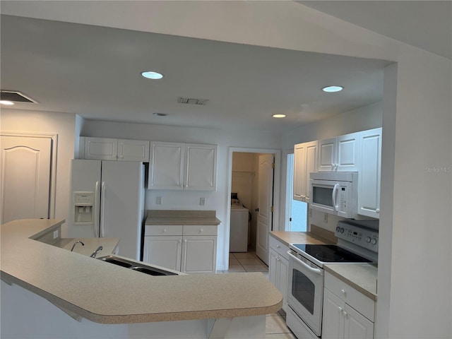 kitchen with white appliances, sink, light tile patterned floors, washer / clothes dryer, and white cabinetry