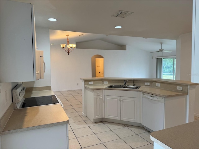 kitchen featuring stove, white dishwasher, white cabinets, sink, and vaulted ceiling