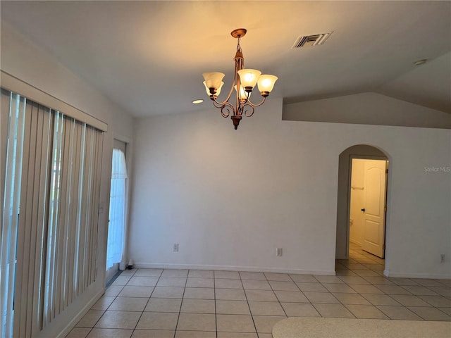 tiled spare room featuring a chandelier and vaulted ceiling