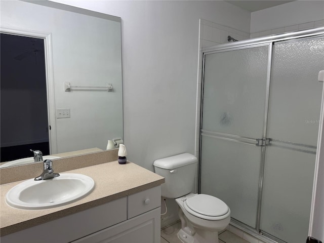 bathroom featuring tile patterned floors, vanity, toilet, and walk in shower