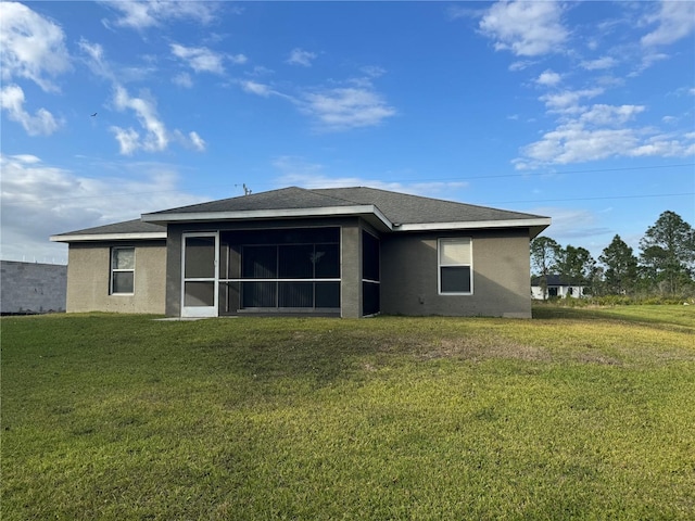 rear view of property featuring a lawn and a sunroom