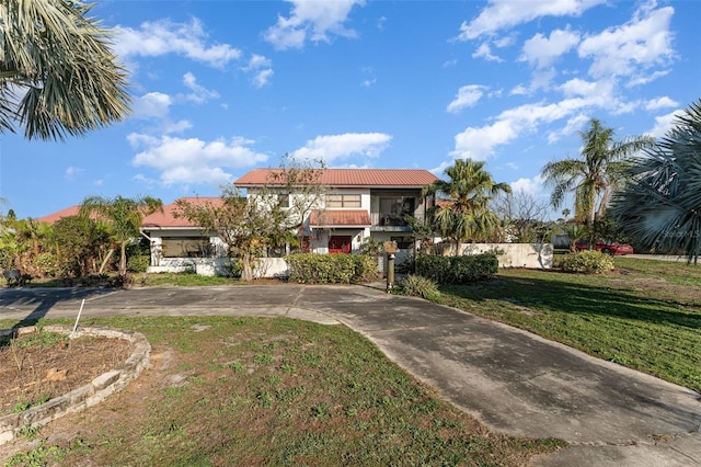 view of front facade featuring a balcony and a front yard