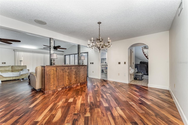 unfurnished dining area with ceiling fan, dark hardwood / wood-style floors, and a textured ceiling