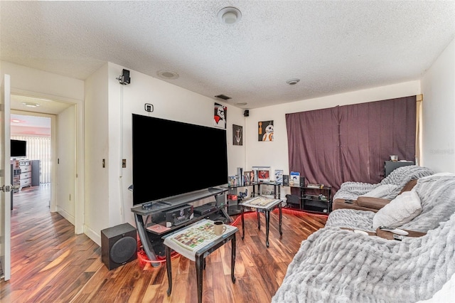 living room featuring wood-type flooring and a textured ceiling