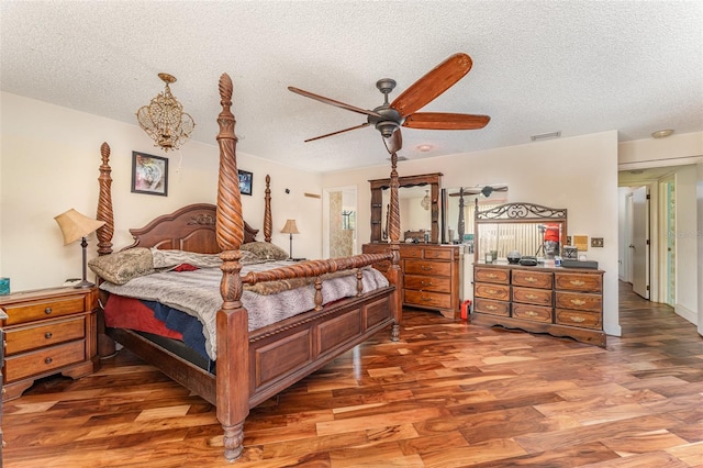 bedroom featuring hardwood / wood-style floors, a textured ceiling, and ceiling fan