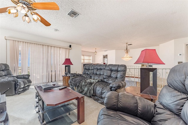 living room featuring ceiling fan, carpet, and a textured ceiling