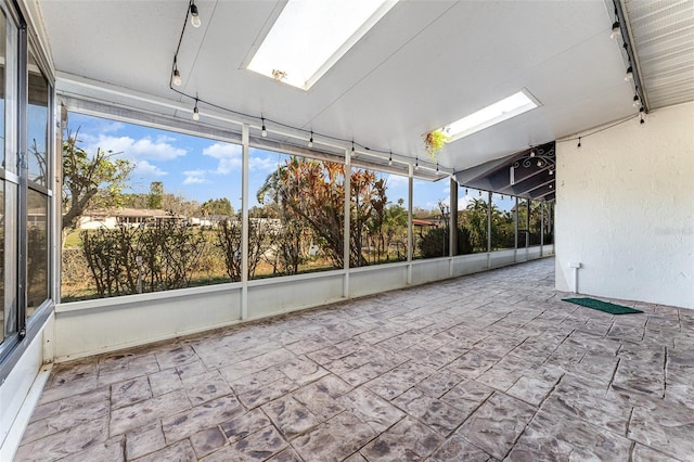 unfurnished sunroom featuring track lighting