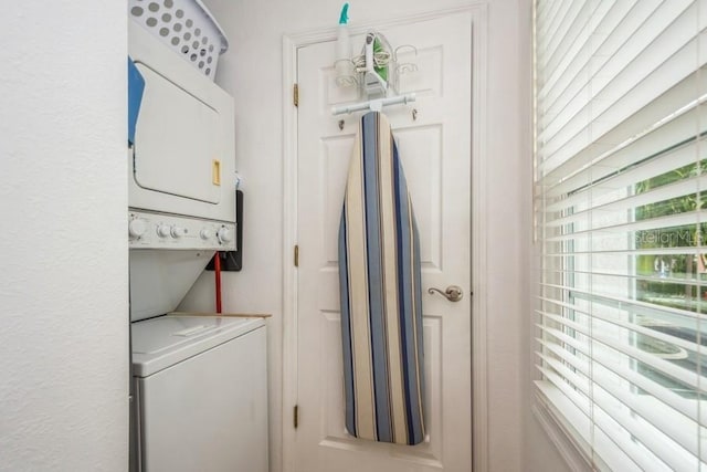 washroom with stacked washing maching and dryer