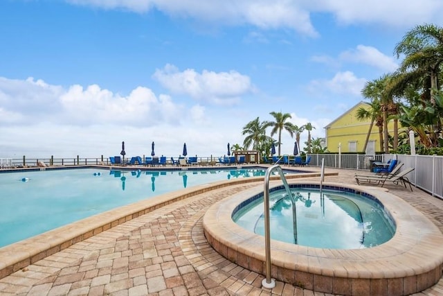 view of swimming pool with a hot tub