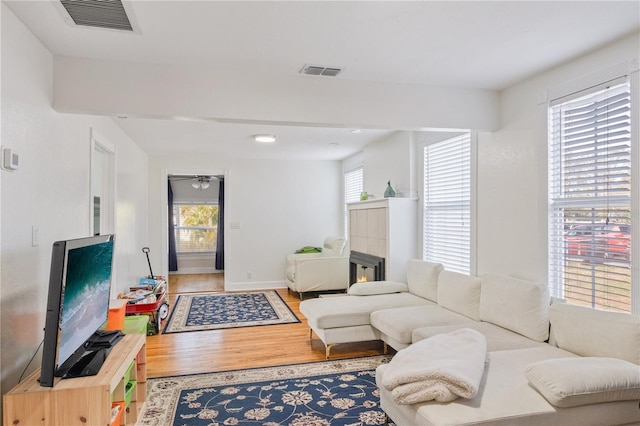 living room with a fireplace, hardwood / wood-style flooring, and ceiling fan