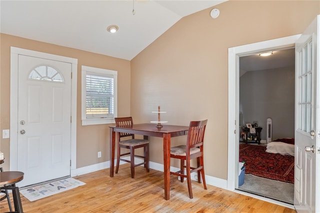 dining space featuring light hardwood / wood-style flooring and lofted ceiling