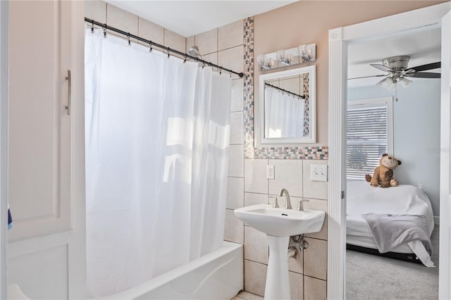 bathroom featuring ceiling fan, shower / tub combo with curtain, and tile walls