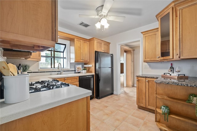 kitchen with a sink, visible vents, a ceiling fan, black appliances, and glass insert cabinets