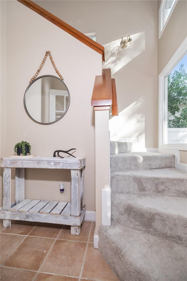 staircase featuring a towering ceiling and tile patterned floors