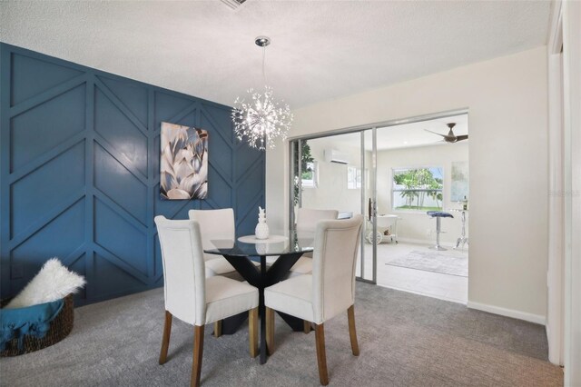 carpeted dining room with a wall mounted air conditioner and ceiling fan with notable chandelier