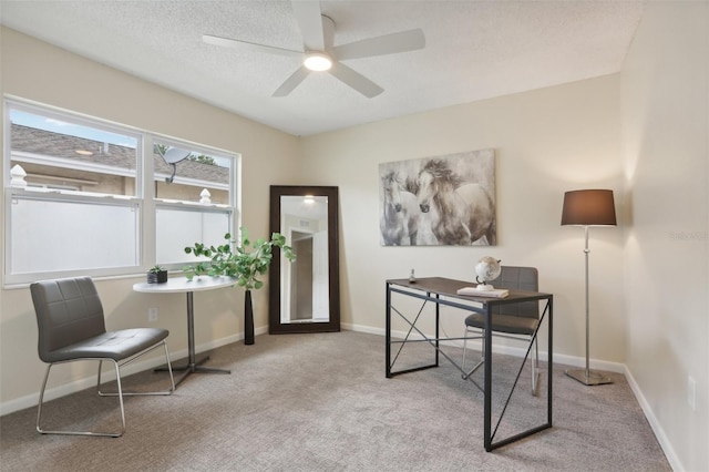 office area featuring a textured ceiling, light colored carpet, and ceiling fan