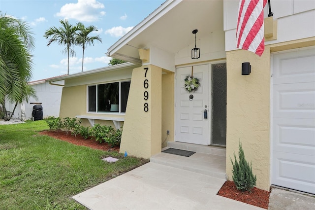 view of exterior entry featuring a yard