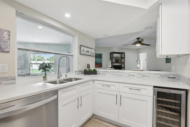 kitchen with wine cooler, white cabinetry, sink, and stainless steel dishwasher