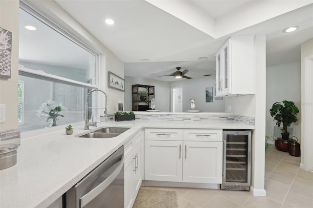 kitchen featuring dishwasher, white cabinets, sink, ceiling fan, and beverage cooler