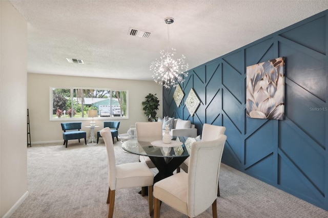 dining room with a textured ceiling, light carpet, and a chandelier