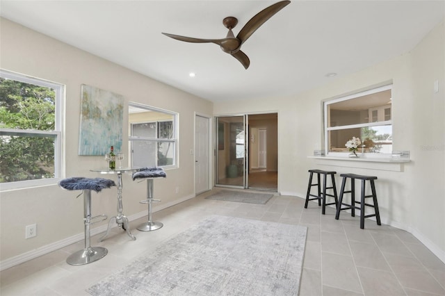 living area with ceiling fan and light tile patterned floors