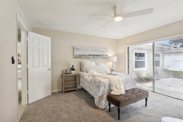 carpeted bedroom featuring multiple windows, a textured ceiling, access to outside, and ceiling fan