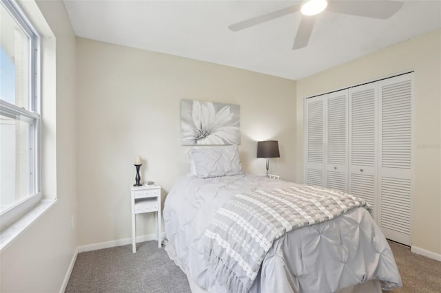 bedroom with multiple windows, carpet, a closet, and ceiling fan