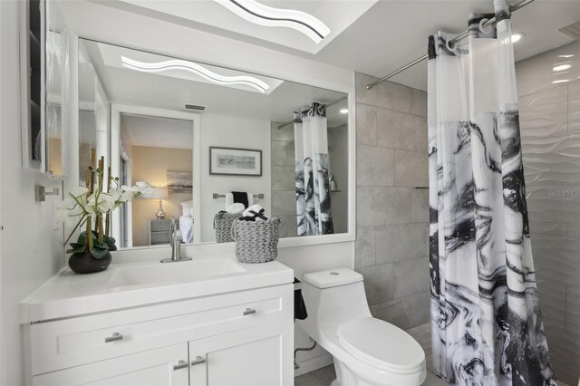 bathroom featuring toilet, vanity, and walk in shower