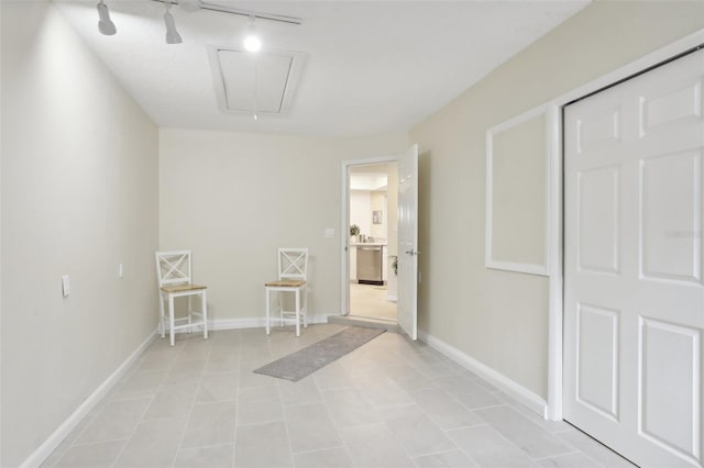 corridor with light tile patterned floors and rail lighting