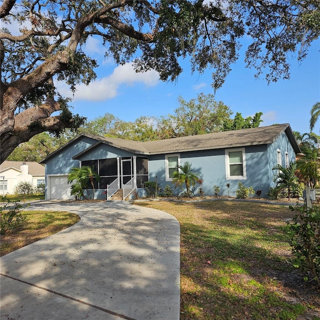 ranch-style house featuring a sunroom, a garage, and a front yard