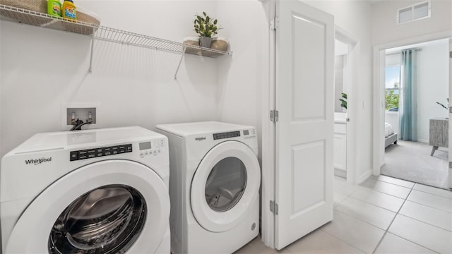 washroom featuring washer and clothes dryer and light tile patterned flooring