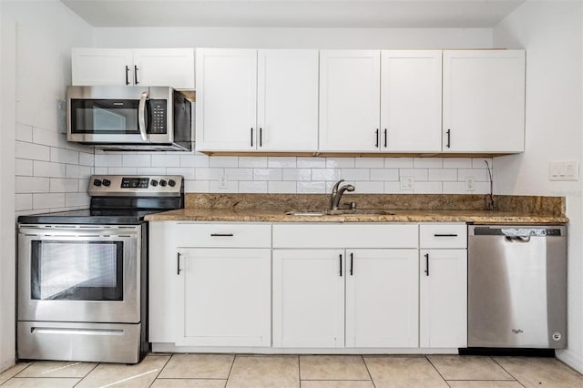 kitchen with backsplash, dark stone counters, sink, appliances with stainless steel finishes, and white cabinetry