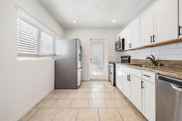 kitchen with white cabinetry, light stone countertops, sink, and appliances with stainless steel finishes