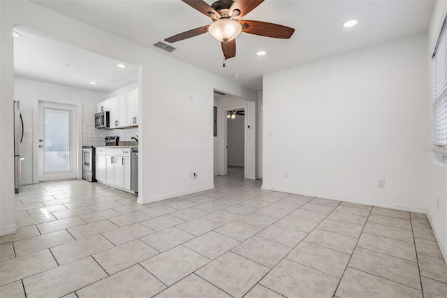 unfurnished living room featuring ceiling fan and light tile patterned floors