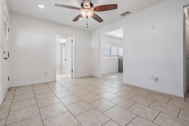 tiled spare room featuring ceiling fan