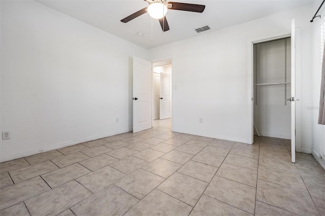 unfurnished bedroom with ceiling fan, light tile patterned floors, and a closet