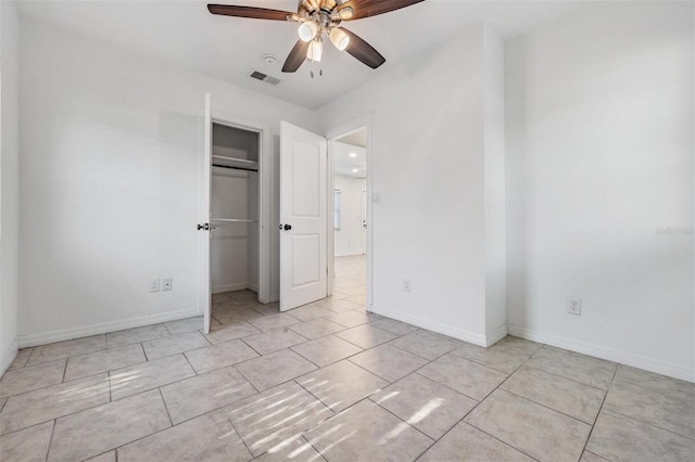 unfurnished bedroom featuring ceiling fan, light tile patterned floors, and a closet