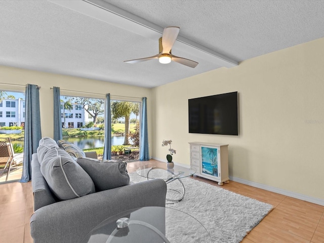 living room featuring beam ceiling, a wealth of natural light, hardwood / wood-style floors, and ceiling fan