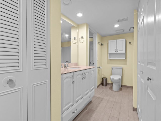 bathroom featuring hardwood / wood-style floors, vanity, and toilet