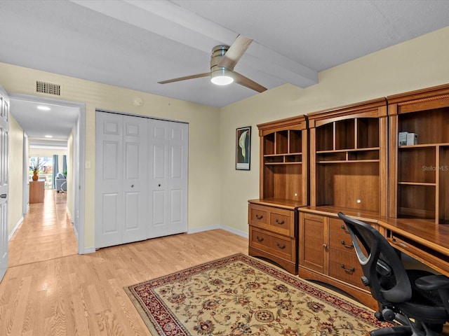 home office featuring ceiling fan, beam ceiling, and light hardwood / wood-style flooring