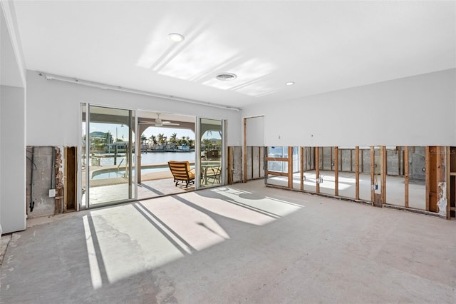 unfurnished room featuring ceiling fan and a water view