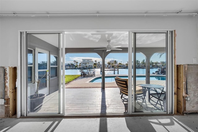 entryway with ceiling fan and a water view