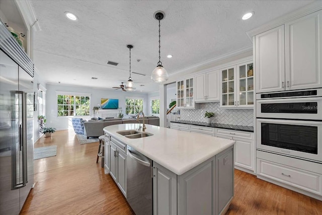 kitchen featuring sink, white cabinetry, an island with sink, and appliances with stainless steel finishes