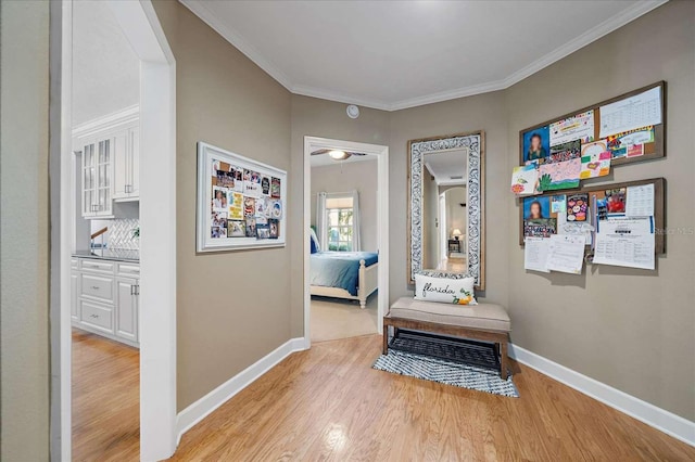 corridor featuring light wood-type flooring and crown molding