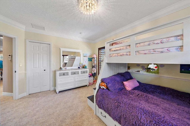 carpeted bedroom with crown molding, a closet, and a textured ceiling