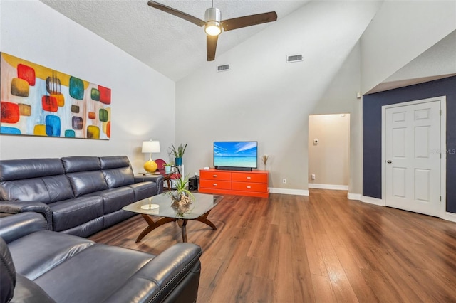 living room featuring ceiling fan, high vaulted ceiling, a textured ceiling, and hardwood / wood-style flooring