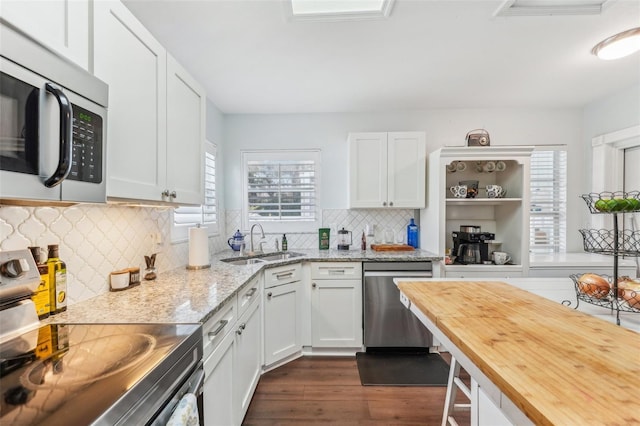 kitchen featuring white cabinetry, sink, stainless steel appliances, and light stone counters