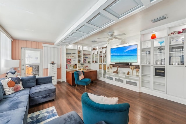 living room with built in shelves, ceiling fan, and dark hardwood / wood-style floors